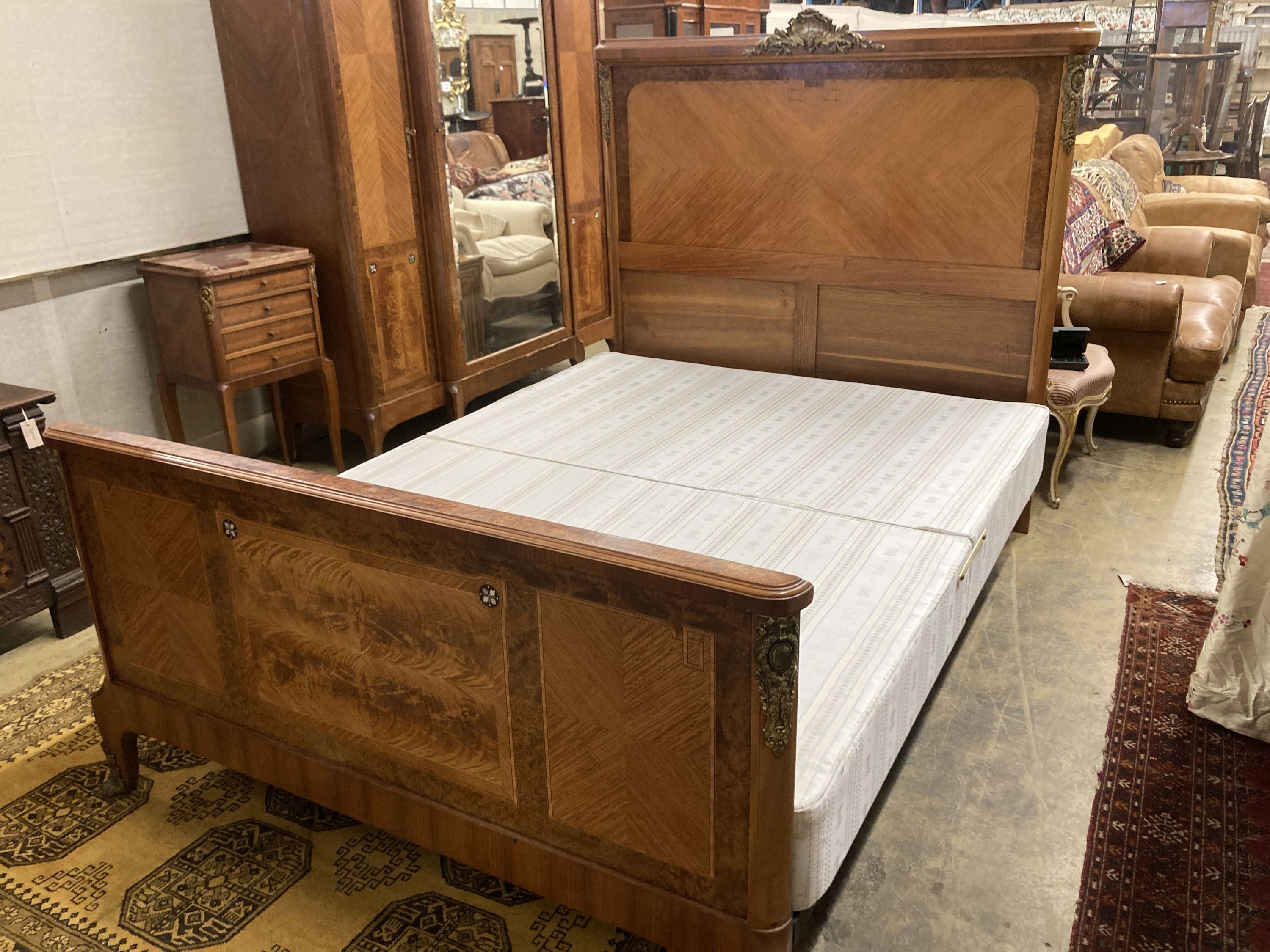 A Louis XVI style three piece gilt metal mounted kingwood bedroom suite, consisting:- an armoire, a bedstead and a marble topped bedside cupboard, armoire W.174cm D.55cm H.224cm